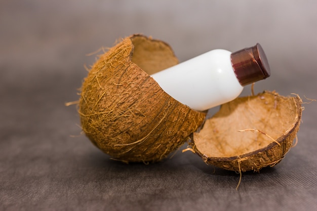 Botella sobresale en una cáscara de coco en gris