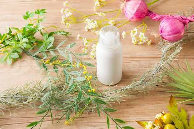 Una botella de spray con una imagen orgánica rodeada de plantas y flores.