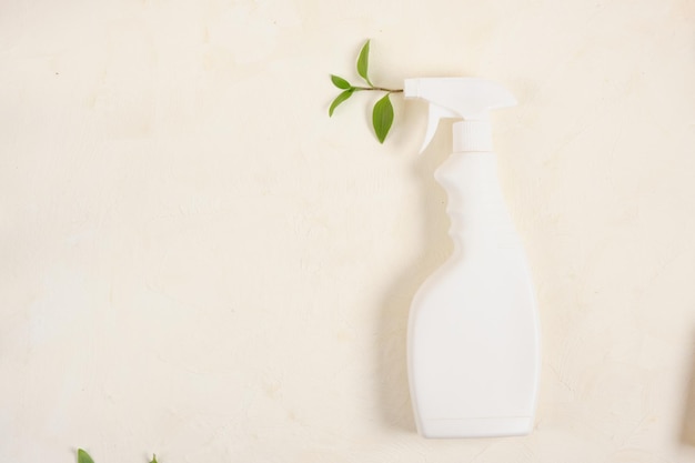 Botella de spray con spray de hojas para conceptos de limpieza natural ecológicos. en el espacio de copia de fondo beige