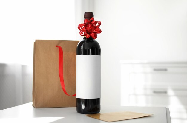 Foto botella de tarjeta de vino y bolsa de papel en la mesa en la sala de luz espacio para texto