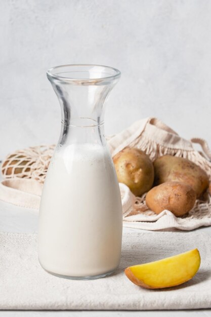 Foto en una botella y en un vaso la bebida es verdura verdura patata no es leche cerca hay pota