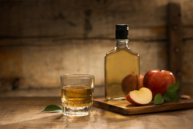 Botella y vaso de jugo de manzana natural y cortes de manzana