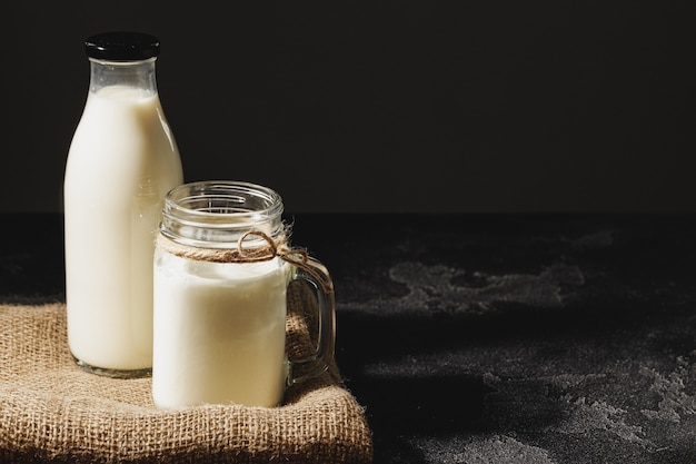 Botella y vaso de leche, vista frontal