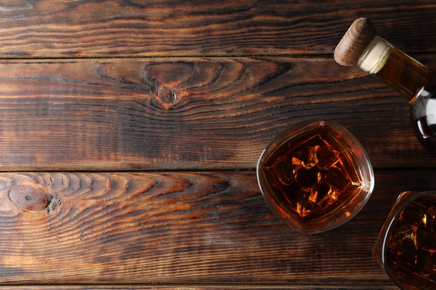 Botella y vasos de whisky en madera