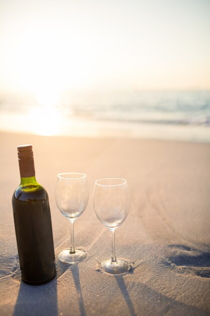 Foto botella de vid con dos vasos