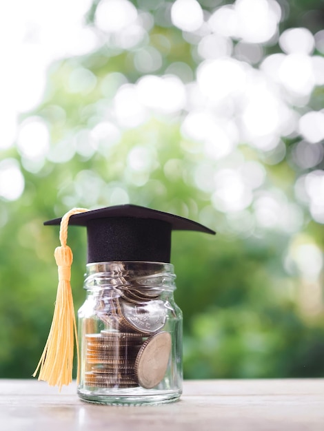 Botella de vidrio con sombrero de graduación El concepto de ahorrar dinero para la educación, préstamos estudiantiles, becas, matrículas en el futuro