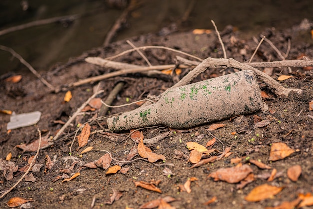 Botella de vidrio en el suelo en un lugar natural.