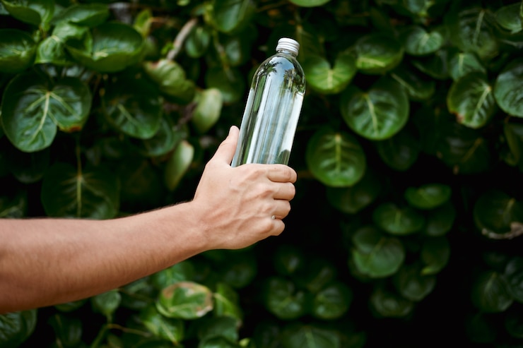 Foto botella de vidrio transparente reutilizable de agua de mano