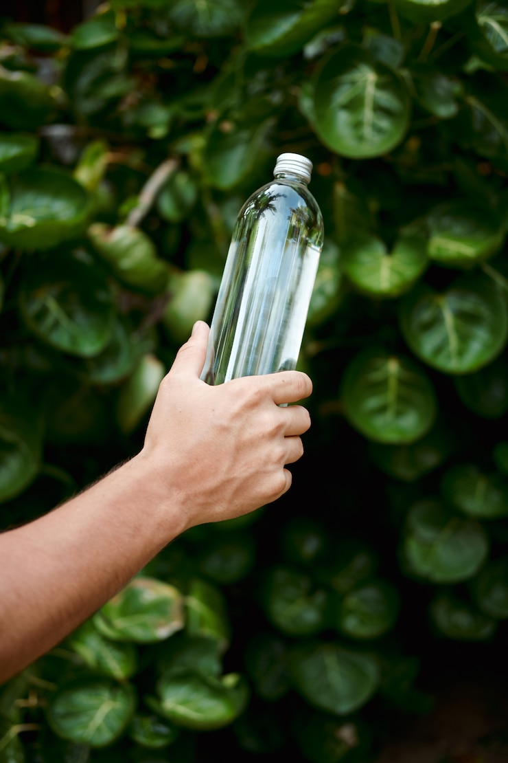 Foto botella de vidrio transparente reutilizable de agua de mano