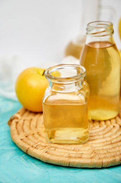 Botella de vidrio de vinagre orgánico de manzana en azul.