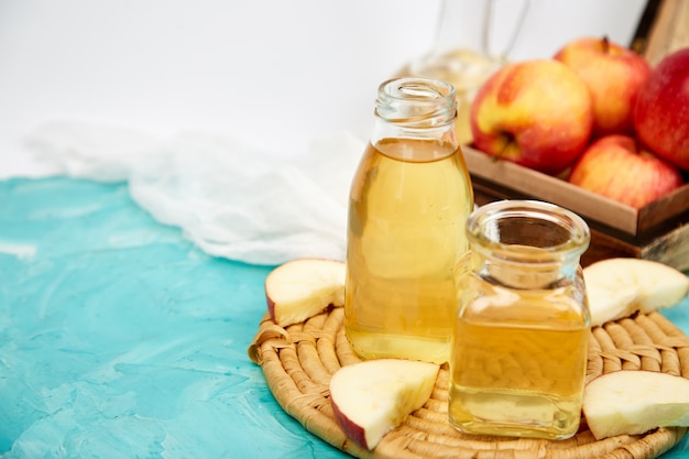 Botella de vidrio de vinagre orgánico de manzana en azul.