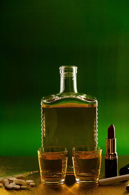 Botella de vidrio con whisky y lápiz labial