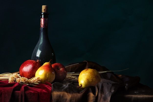 Una botella de vino añejo y fruta madura en un oscuro