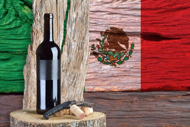 Botella de vino con la bandera de México al fondo