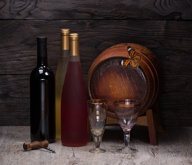 Botella de vino y barril de madera para vino en una mesa de madera bodegón taberna