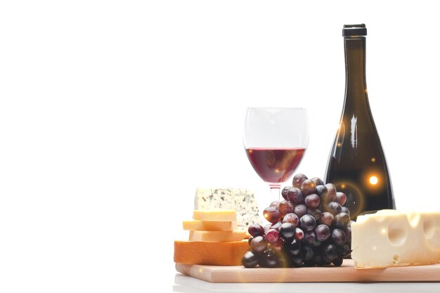 Botella de vino, copa de vino, queso y uva en el plato de madera