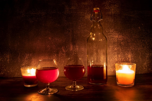 Una botella de vino con copas a la luz de las velas