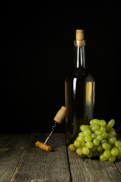 Botella de vino de cristal con corchos en el fondo de la mesa de madera