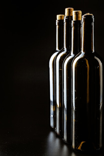 Foto botella de vino en un negro oscuro