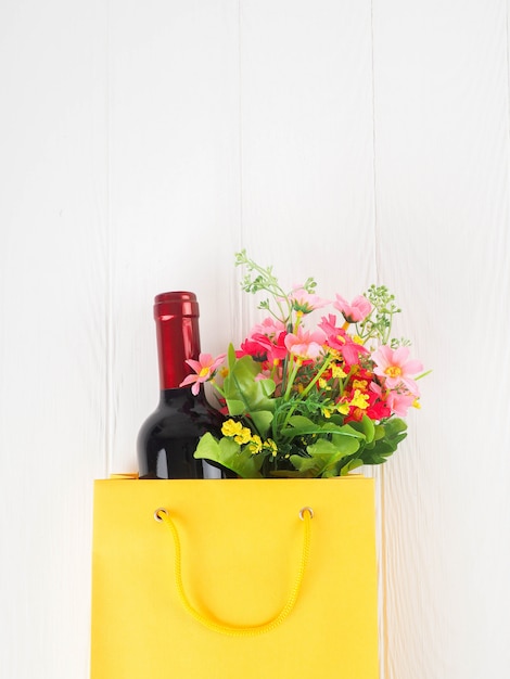 Botella de vino en el paquete con flores, aplanada