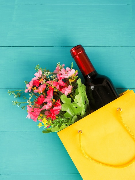 Botella de vino en el paquete con flores, aplanada