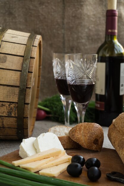 Botella de vino, queso y pan blanco están en saqueo.