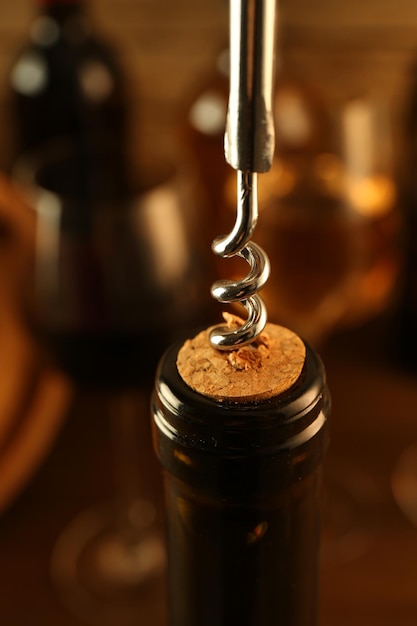 Botella de vino con sacacorchos en primer plano de fondo borroso