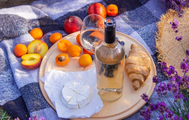 Una botella de vino sobre un fondo de un campo de lavanda Copas con frutas de vino