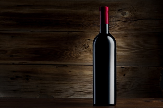 Foto botella de vino sobre un fondo de madera
