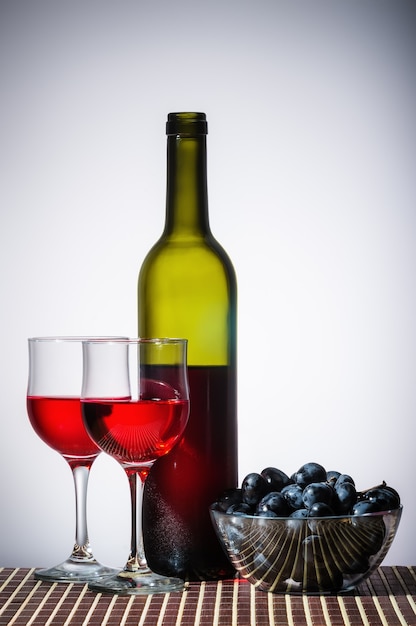 Foto botella de vino tinto y copas de vino.