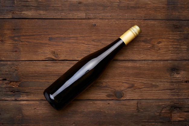 Botella de vino tinto en el espacio de la mesa de madera. Vista superior con espacio de copia