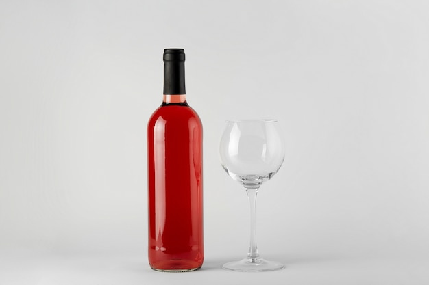 Botella de vino tinto con vino rosado aislado en blanco