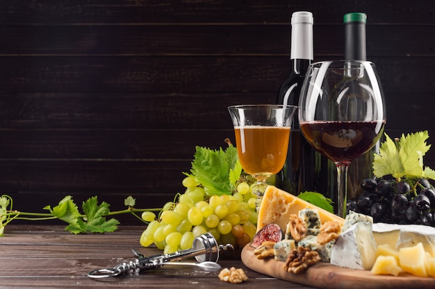 Botella de vino y uva en mesa de madera