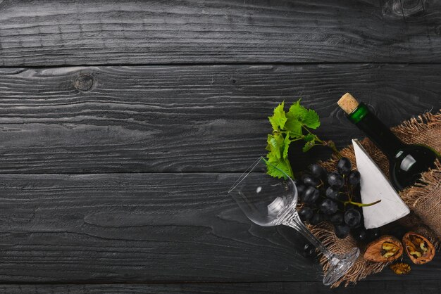 Una botella de vino y uvas Sobre un fondo de madera Vista superior Espacio libre para su texto