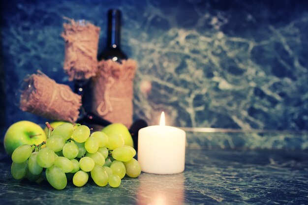 Botella de vino con vidrio y uva blanca.