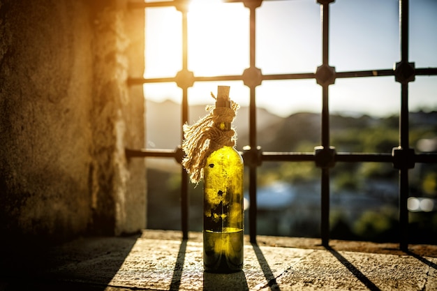 Botella de vino vieja y polvorienta en el alféizar de la ventana