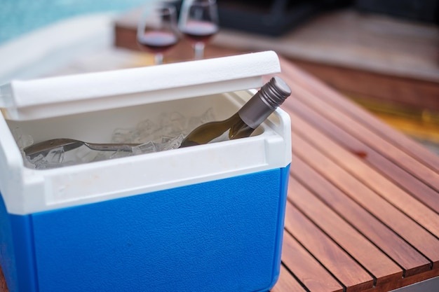 Botella de vinos tintos junto a la piscina. Concepto de viajes de verano, vacaciones, vacaciones y fin de semana feliz