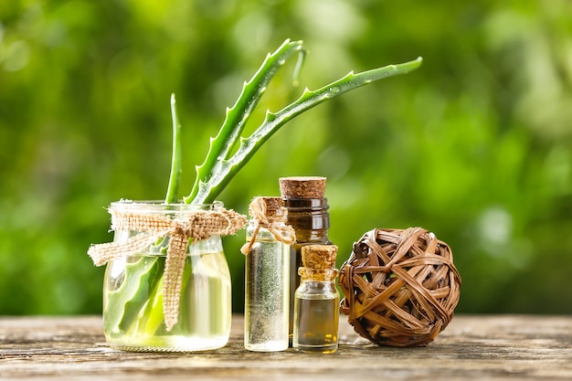 Botellas de aceite esencial de aloe en mesa de madera