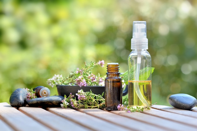 Botellas de aceite esencial y flores de hierbas aromáticas.