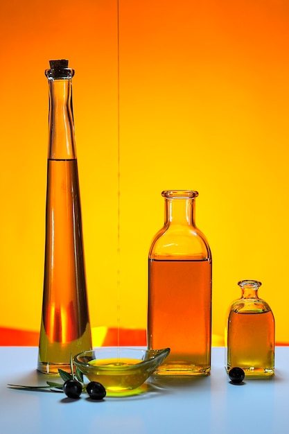 Botellas de aceite de oliva virgen, con fondo de color.