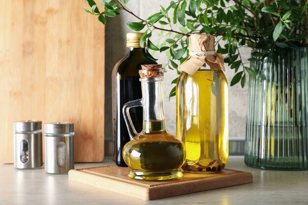 Botellas con aceite y plantas en la mesa de la cocina