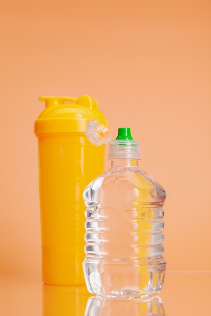 Botellas de agua de plástico sobre un fondo beige pastel
