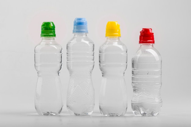 Foto botellas de agua de plástico con tapas de colores.