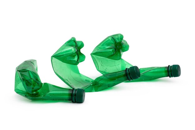 Botellas de agua de plástico verde vacías escaladas para reciclar aisladas sobre fondo blanco Concepto de reciclaje