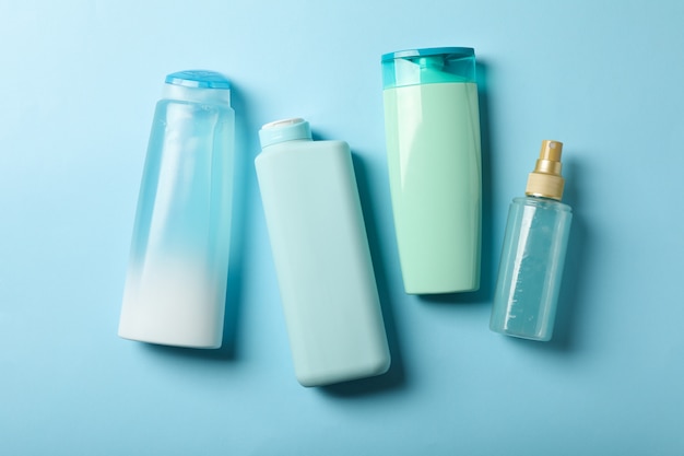 Botellas en blanco para cosméticos sobre fondo azul.