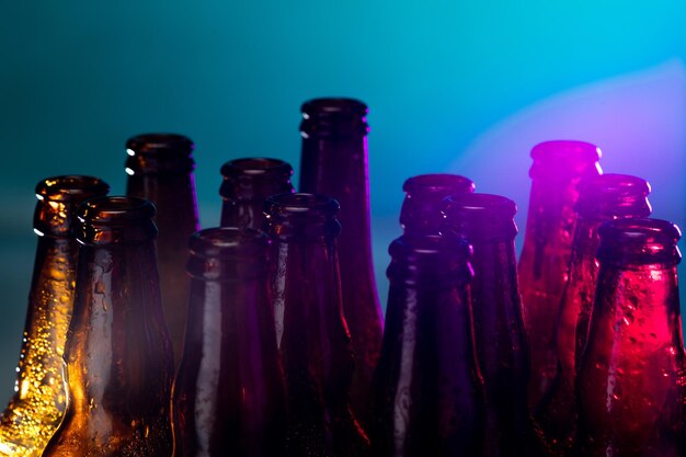 Botellas de cerveza de color neón de cerca sobre fondo brillante studio