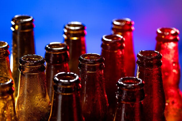 Foto botellas de cerveza de color neón. cerrar sobre fondo de estudio brillante