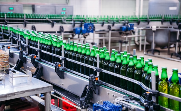 Botellas de cerveza en el transportador.