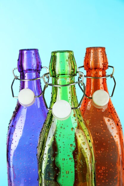 Botellas de colores sobre fondo azul claro