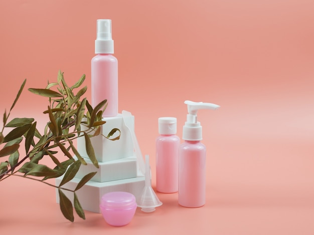 Botellas cosméticas rosadas para el concepto cosmético del cuidado de la piel de la loción del gel crema